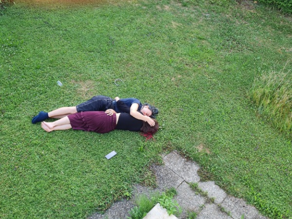Indi und Nessie von oben fotografiert 2 Frauen liegen umarmt zusammen auf der Wiese